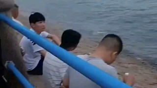 “涨潮期间，一个浪就下去了”青岛海边，一位当地大哥挨个提醒坐在栏杆外的游人退回来
