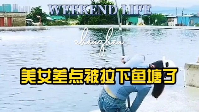 美女差点被拉下鱼塘了