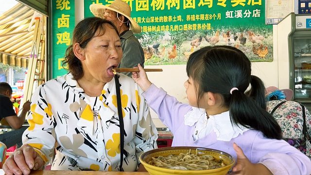 奶奶接孙女放学，给孙女买好吃的，自己却舍不得吃