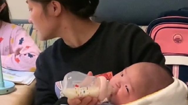 边辅导作业边奶孩子的家长