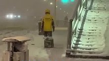 大雪夜外卖员艰难送餐，路滑无法骑行只能步行，一步一步拖着送餐箱前行