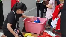 女孩踩到汤汁弄脏地摊上的衣服，家长买下全部脏衣服