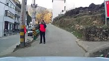 开车上山被人拦下，原来是村里的志愿者，因路窄充当“人工红绿灯”。