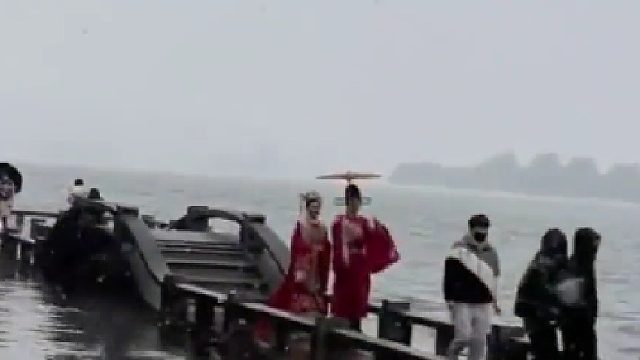 新人在雪中西湖拍婚纱照，路人纷纷驻足围观，他朝若是同淋雪 此生也算共白头