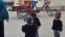 家长带四胞胎女儿外出，怕走丢用绳子牵着