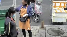 女子路边嗑瓜子时不慎掉钱，发现后眼睁睁看着被路人捡走