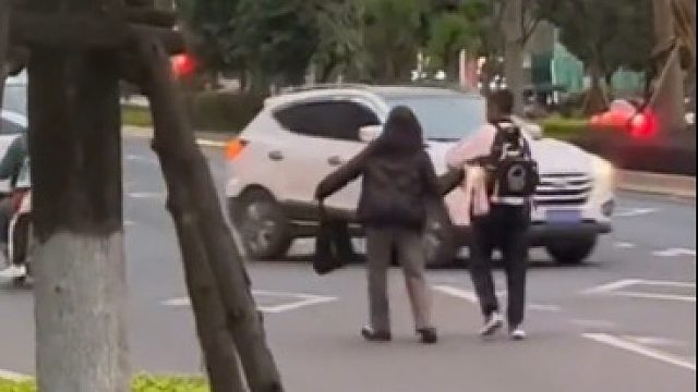 男孩或因压力大，走到马路中央，路人小姐姐看到后，冲上去一把拉回触动网友