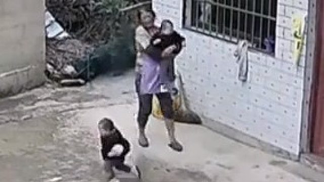 下雨天双胞胎轮番往院里跑，奶奶抓住这个跑了那个，孩子开心了，就是有点费奶奶