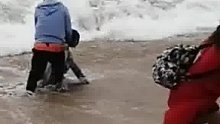 女游客捡拖鞋险些被卷入大海，同伴束手无策，男子挺身相救！目击者：大伙不让她去她非去