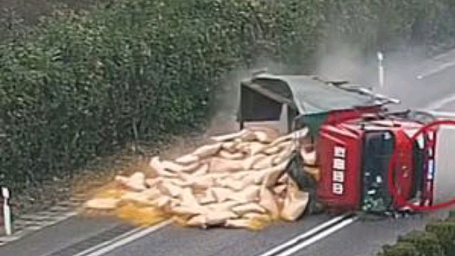 货车爆胎侧翻货物洒落一地