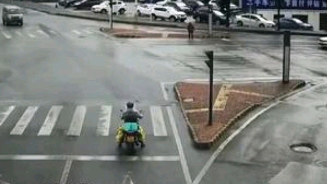 摩托车司机正在路口等红灯，突然驶来一辆白色轿车“360°漂移”把他撞飞