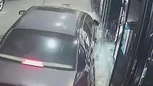 晚上男子正在店门口打扫，汽车冲着店门撞来