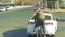 白色轿车欲右转突然停车，男子骑车躲避不及导致追尾！