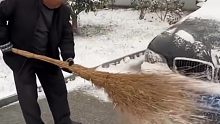 父亲用扫帚给岁儿子的车扫雪，每条痕迹都是父爱