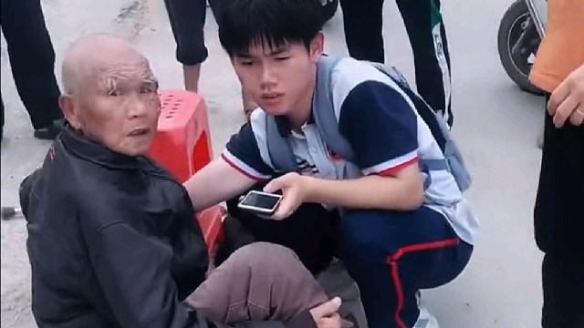 一位老人在路上不慎摔倒，路过学生见状上前搀扶