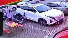 男孩碰倒电动车砸伤轿车，家长带孩子不管不顾淡定离开，车主：家长的这种态度让人不舒服。