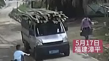 孩子骑车突然冲出 造成小货车急刹 车上的竹子因惯性滑落一地