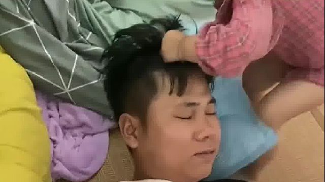 爸爸在床上睡觉，小女孩“贴心”给爸爸垫枕头