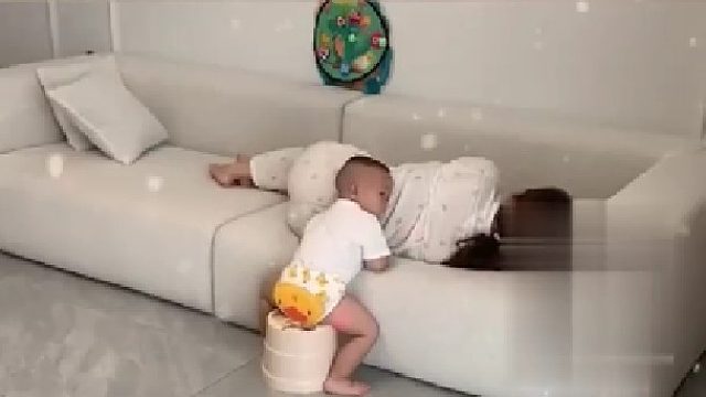 妈妈沙发上睡着差点掉下来，一岁多宝宝搬来凳子暖心守护。