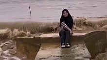 女子坐在岸边拍照，没想到下一秒巨浪直接翻涌上岸……