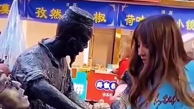 美女真调皮给雕塑喂水