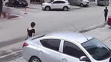 轿车失控撞向看手机的路人，男子极限一跳躲过车头。