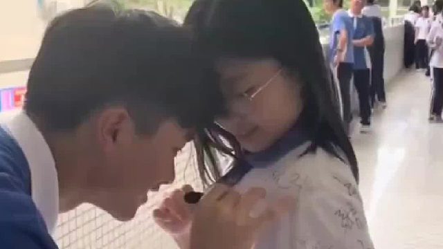 临近毕业的同学们，在彼此的校服上签字留念