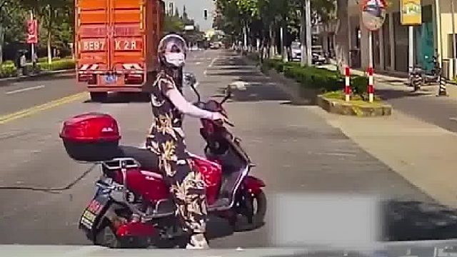 女子开车见电动车在路中间掉头，慢行等候却遭电动车主怒视！