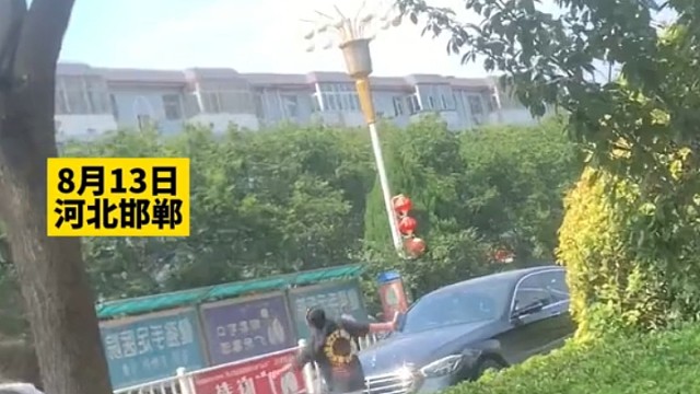 女子马路上拦车要钱，不给就转圈圈用脚抵在车头上，“不知道要多少钱，光找那种好车”