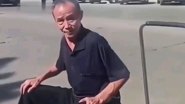 大爷在马路中间摆摊，路人见状上前训斥