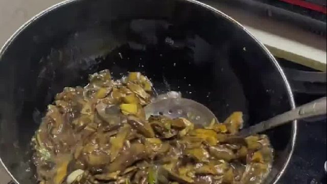 妈妈炒了十分钟的菌子，让儿子尝尝熟了没有。