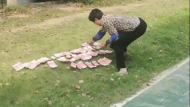 大娘霸气侧漏路边晒钱。