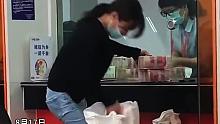 女子拿着两麻袋，在银行柜台霸气存钱。