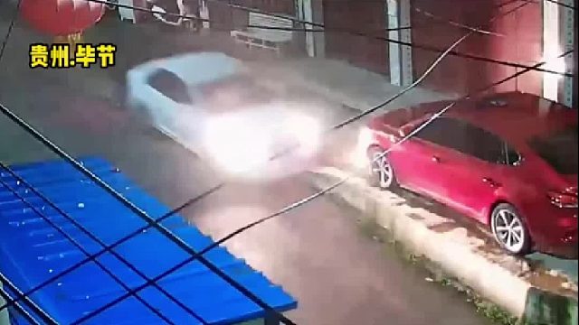 白色轿车以较快的速度撞向路边停放的红色轿车后瞬间翻覆！