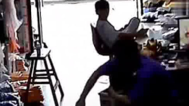 小女孩撑着快要倒下的桌子，大声叫喊向爸爸求助。爸爸和哥哥沉迷手机并没有理会