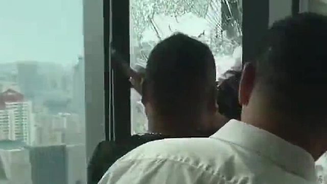 高层作业时不慎滑落，男子死死拽住绳子求生，楼下业主砸碎自家玻璃救人