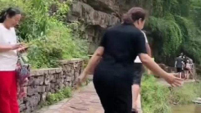 大妈不走寻常路，滑倒跌入水中