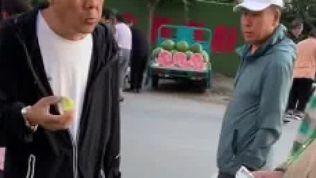 因为疾病浑身不停颤抖的大哥在街边卖水果，黑衣大哥看出其难处默默的买了好多