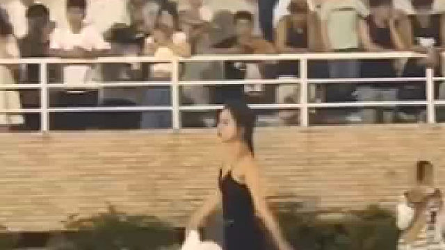 女子持长绸扇跳舞，引众人围观喝彩