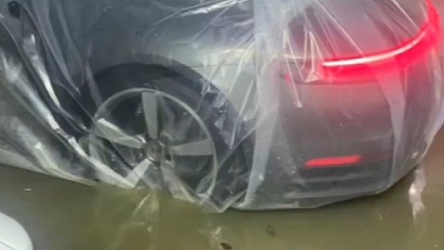 福建福州一车主将爱车装入塑料袋防水：整个地库就我的车没事