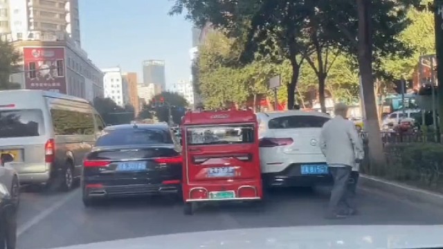大爷低估了车辆的“体型”，卡在两车中间出不去了，这么点空子也想钻，路上安全第一