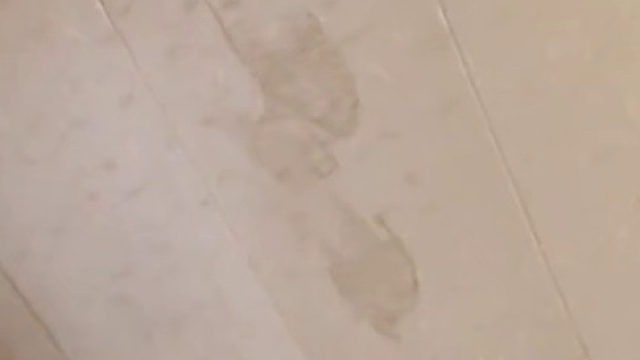 男子称出门半天回家后发现，客厅天花板上突然多出四五个脚印