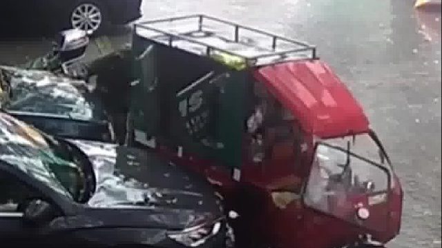 雨天快递小哥送货时忘熄火，快递车自己启动撞向路边小车和老人！