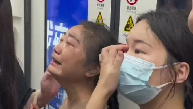 上海地铁，一女子背部被地铁门夹住痛哭，男子打开紧急开门装置解救