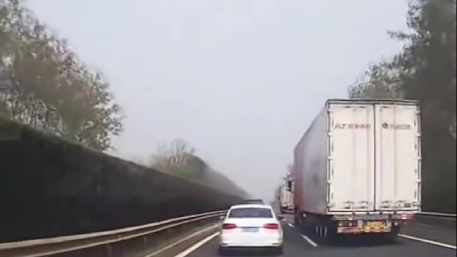 大车在高速上强行变道，把小车挤至紧贴隔离带！