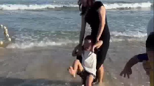 夫妻俩在海边拍照秀恩爱，一姨带娃在风中凌乱，都快抑郁了