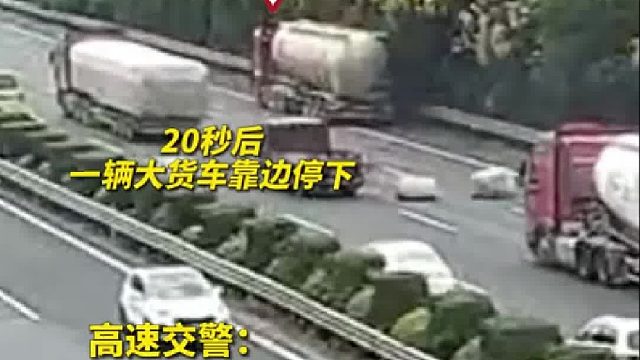 高速公路上掉落大袋货物，热心货车司机在车流中搬离货物！