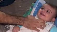 巴勒斯坦一家三口被救后，父亲把安置在水泥地上的孩子逗的咯咯大笑#巴以冲突