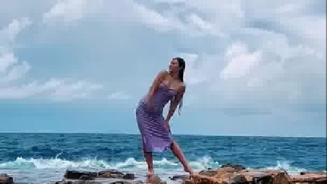 女生在海边与海浪合拍，每一波的都完美适配，太酷了