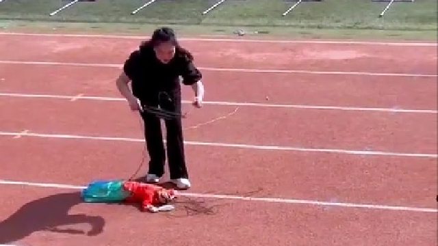 女子把木偶带到运动会上...